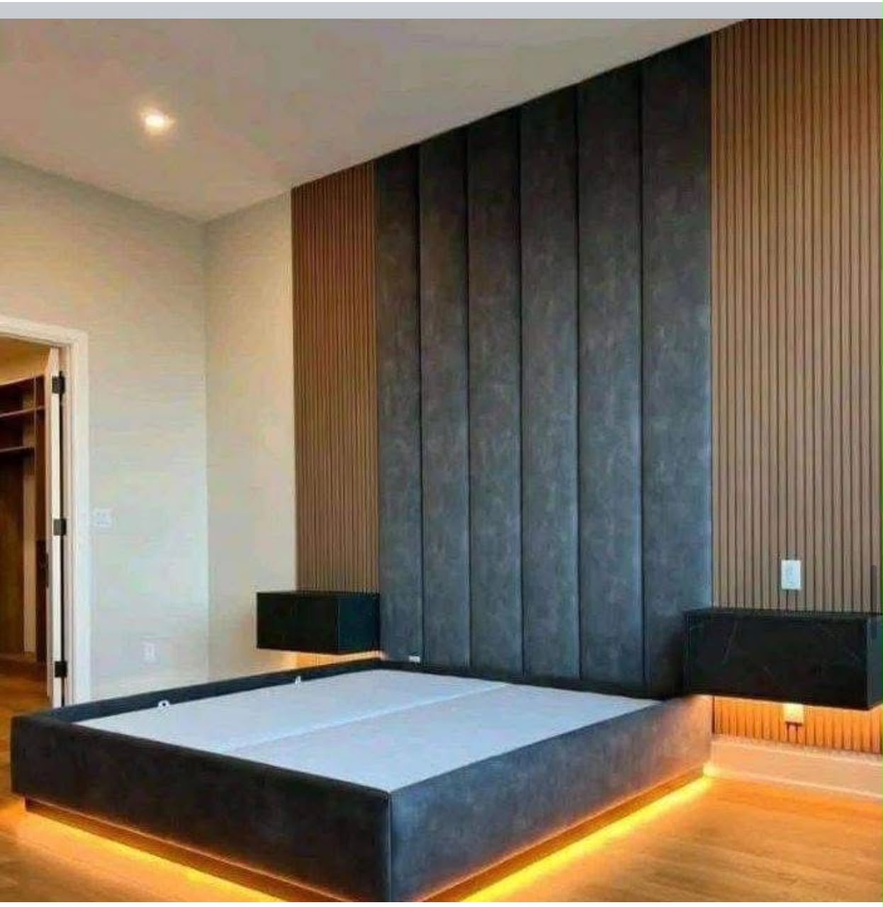 Bedroom with tall upholstered wall panels and warm lighting